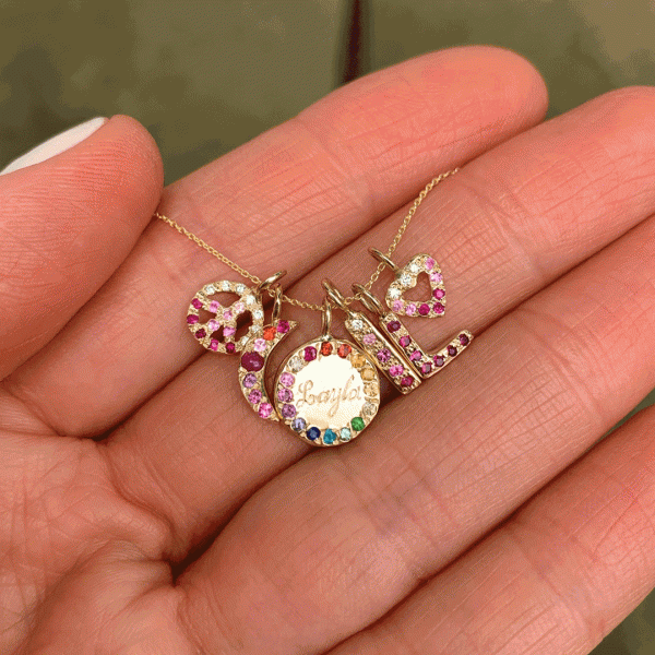 charmjewelry Size guide for size of the charms - holding gold peace charm, gold moon charm, gold circle charm, gold skinny bar charm, gold letter charm and heart charms with personalized gemstones