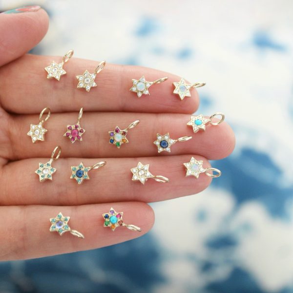 hand out holding different gemstone variations of the star charm