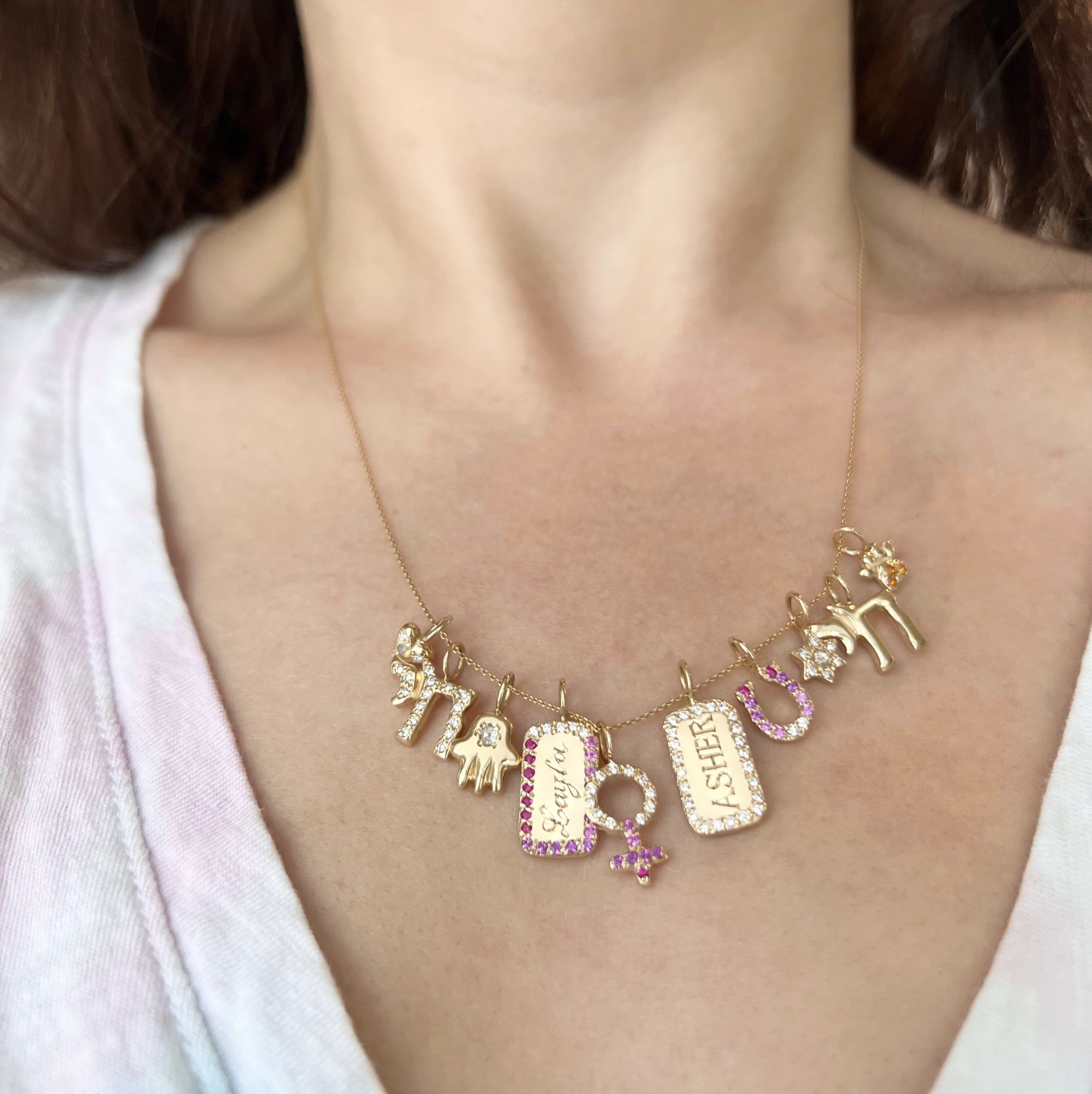 5 new charms by Elisa seen worn on a necklace