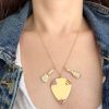 Wearing a necklace with the new rainbow colored gemstone 14k yellow gold guitar charm, the rainbow colored 14k yellow gold guitar pick charm, and another 14k yellow gold guitar charm with white diamonds