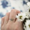 hand wearing the star ring by elisa solomon and holding flowers
