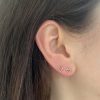 wearing the tiny open heart stud earrings in 14k yellow gold with ruby gemstones