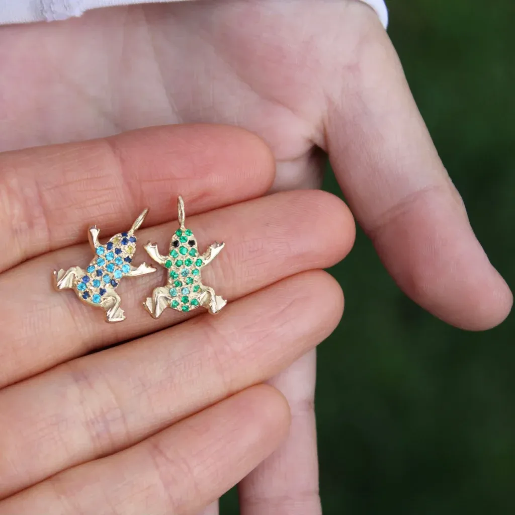 frog charm in gold with precious gemstones, up-close view, holding in hands